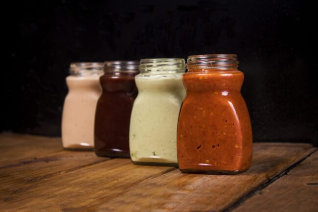 Closeup shot of various sauces in glass jars